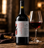A bottle of Egel Bikeraper Superior 2022 red wine stands on a rustic wooden table next to a filled wine glass, with a warm, blurred background.
