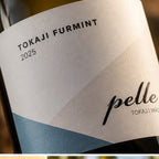 Close-up of a wine label reading 'TOKAJI FURMINT 2025' with the brand name 'pelle' partially visible, on a dark bottle background.
