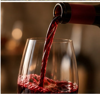 Red wine being poured from a bottle into a clear wine glass, with a warm blurred background.
