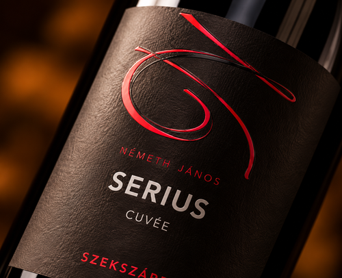 Close-up of Németh János SERIUS Cuvée wine label featuring elegant red lettering on textured black paper.